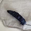 Close-up of a pleated navy blue denim fabric banana hair clip with a sturdy plastic structure - Dark Denim Banana Clip