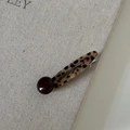 Dettaglio molletta per capelli leopardata con perla marrone su sfondo di un libro in lino - 4# Fermaglio Capelli Leopardato Perla Marrone