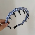 Détail d'un serre-tête en tissu à carreaux bleus avec dents antidérapantes et bord large - Style rayé bleu