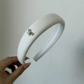 Dettaglio del cerchietto imbottito bianco con un delicato fiocco in metallo argento - 3# Cerchietto Saia Bianco