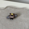 Close-up of a brown cartoon bear hair clip with a blue and grey plaid pattern base - Blue Striped Oval Bear