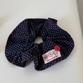 Gros plan sur chouchou bleu marine à pois avec surpiqûre rouge et étiquette décorative - Bleu Blanc à Pois