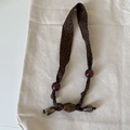 Close-up of vintage leopard print fabric necklace with red beads and horn-style pendants - Wide Leopard Beads Style