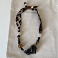 Detalle del collar de tela con estampado de leopardo, cuentas de ámbar y colgante de corazón - #3 Collar Corazón Negro