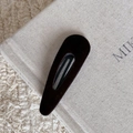 Barrette à cheveux ovale en velours marron foncé sur un livre beige, style esthétique - Pince à cheveux goutte d'eau marron
