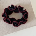 Detail van vintage zwarte scrunchie met bordeauxrode ruches op linnen textuur achtergrond - Zwart Gegolfd Haarelastiekje