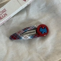 Détail de la pince à cheveux à carreaux rouge et bleu avec bouton et motif chien - Style Chien Rond Rouge