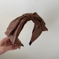 Nahaufnahme des braunen Falten-Haarreifs mit feiner Stoffstruktur und Knotendesign - Kaffeebraun