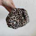 Detailed close-up of a leopard print scrunchie decorated with elegant white faux pearls - No.1 Leopard Pearl Hair Clip