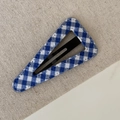 Detailed macro view of the blue and white checkered fabric texture on a triangle hair clip - Blue White Cross Striped