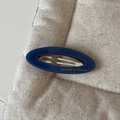 Barrette ovale rétro en acétate bleu foncé avec lettrage doré sur fond textile beige clair - Pince à Cheveux Ovale Bleu Foncé