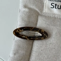 Détail macro d'une barrette ovale en acétate avec motif écaille sur pochette en lin - Dark Leopard Print Oval Hair Clip