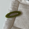 Détail de la barrette ovale en acétate vert olive avec inscription dorée élégante - Pince Ovale Verte