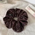 Elegant leopard print satin scrunchie for hair styling on soft linen with accessories - Flocked Leopard Print Hair Tie