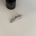 Detailopname van een zilveren satijnen strik haarklem met donkere edelsteen en kristallen - Strikstijl / Zilveren Strik
