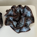 Detalle de un coletero retro grande a cuadros azules con ribete marrón y tela plisada - Raya Azul Café