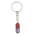 Detalle de un colgante de cápsula rojo y violeta brillante en un llavero plateado - Estilo Cápsula de Píldora (4)