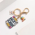 Golden back to school keychain featuring a windmill and heart balloon cluster charm - Pencil Style