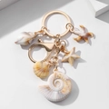 Detail shot of golden seashell keychain with detailed resin starfish and conch charms - Slender Conch Style (款式一)