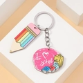 Macro detail of wooden rainbow pencil charm and pink school theme pendant on a key ring - I Love School Style (Style 5)