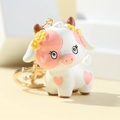 3D cute cartoon cow keychain made of resin with golden ring and pink heart details - Pink