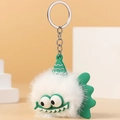 Detail of white furry monster keychain with green silicone hat and metallic ring - White