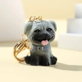 Detail of grey pug keychain with realistic fur texture and gold metal ring on yellow background - Pug