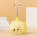 Close-up of yellow fuzzy monster plush keychain with cartoon eyes and silver metal ring - Yellow