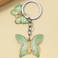 Dettaglio di farfalle in resina verde con venature dorate su portachiavi in metallo argento - Verde