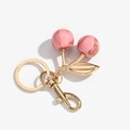 Detail of pink marble resin cherry keychain with gold metal leaf and lobster clasp hook - Gradient Pink