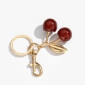 Detailed macro view of red resin cherry keychain with glitter and golden leaves charm - Wine Red Glitter