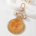 Exquisite gold shell keychain featuring natural scallop design and elegant white faux pearls - Yellow