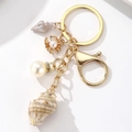 Detail shot of ocean theme keychain with natural conch, pearl and gold shell charms - Style 5