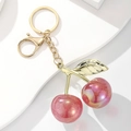 Makroaufnahme der Kirsch-Schlüsselanhänger aus Harz mit Goldblatt und Glitzerdetails - Glitzer Rosa