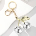 Detailansicht der spiegelpolierten Kirsch-Schlüsselanhänger in Gold und Silber mit Blättern - Spiegel Silber