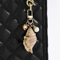 Dettaglio del ciondolo per borsa con conchiglia bordata d'oro e perle su borsa nera - Stile Chiusura Piccola