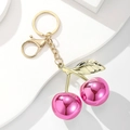 Polished magenta cherry keychain with golden leaves and lobster clasp on white background - Mirror Rose Red