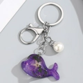 Detalle del llavero de ballena de resina morada con diseño de estrella y perla - Morado