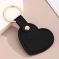 Détail d'un porte-clés cœur en cuir PU noir avec anneau doré et coutures faites main - Noir