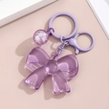 Detail of lavender purple acrylic bow keychain with transparent bubble pendant and metal clasp - Purple