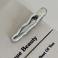 Makroaufnahme einer gewellten Haarspange aus Metall mit cremefarbenen blauen Punkten - Cremeweiß Wellig Blaue Punkte Clip