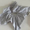 Détail d'un chouchou gris clair avec broderie florale délicate et tissu texturé fin - Style Nœud Bleu