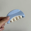 Detalle de una pinza para el cabello grande de resina azul y crema sostenida por la mano - Óvalo Azul Crema (5980676935788)