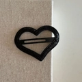 Vista macro di un fermaglio per capelli a cuore con glitter neri su tessuto beige - Cuore Nero (2#)