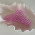 Detalle de una pinza para el cabello a cuadros rosas sobre una bandeja blanca de concha - Pinza para el Cabello a Cuadros Rosa y Blanco