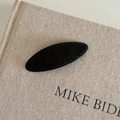 Close-up of black oval BB hair clip with textured fabric surface on a linen book - Black Oval (9#)