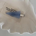 Detalle de una pinza para el pelo a cuadros azules y blancos en un plato de cerámica - Horquilla Triángulo Cuadrícula Azul