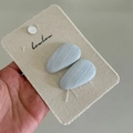 Detail shot of two mint blue ribbed fabric hair clips on a textured card display - Solid Blue Waterdrop Clip Pair