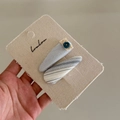 Dettaglio di fermagli per capelli a fiocco a righe blu con pizzo e bottoni su carta - Coppia di Clip Bottone a Goccia d'Acqua Blu
