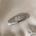 Detalle de una pinza para el pelo plateada con lazo y pedrería en un plato de cerámica - Pinza de Cabello Ovalada Plata con Lazo (2#)